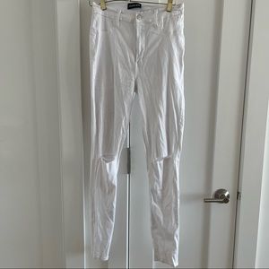 White stretchy skinny denim jeans with distressed rips at knees